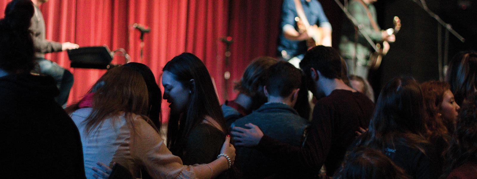 three guitarists 和 drummer leading worship in chapel service